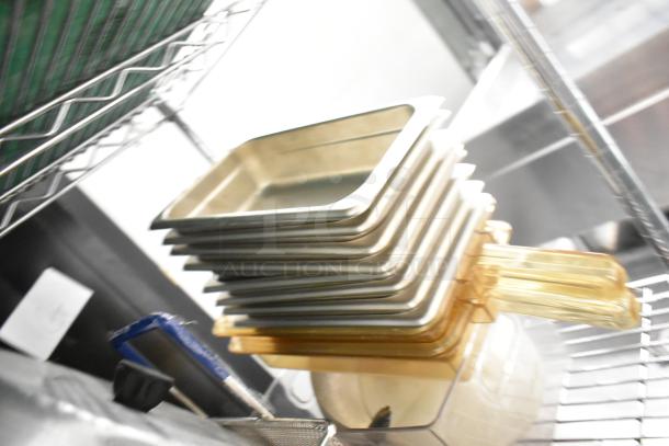 Stack of various kitchen items including stainless steel drop-in bins and poly pitchers, in good condition. Shelving not included.