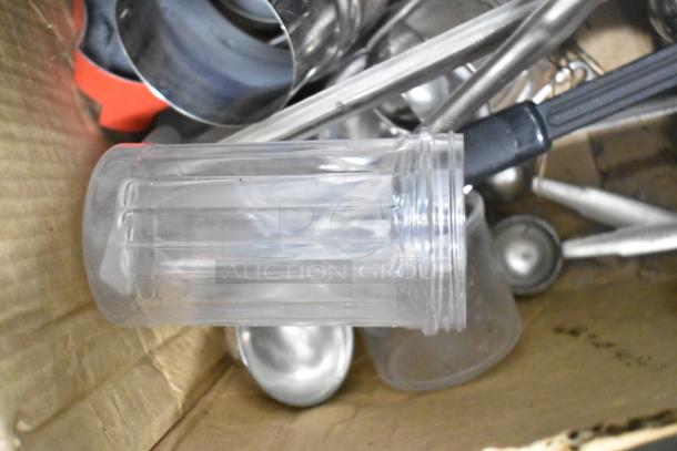 Metro lot including drop-in bins, clear poly pitchers, cutting boards, rice cooker inserts, and utensils in a cardboard box.