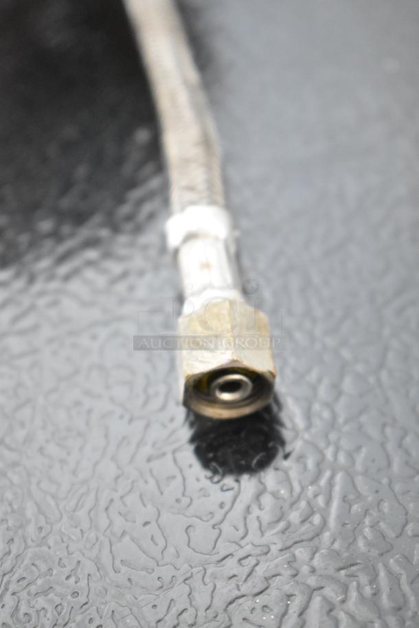 Close-up of a braided hose fitting from the General Electric GE ZDIS150WSS E ice maker, showing wear.