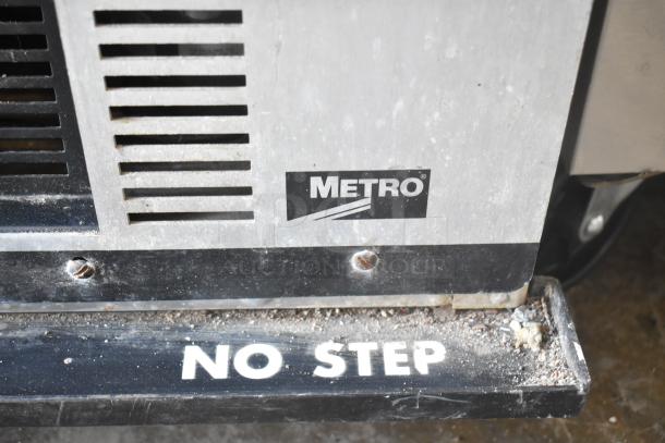 Metro HM2000 heated holding cabinet on casters, 115V, 1 phase. Features "No Step" warning. Visible Metro branding.