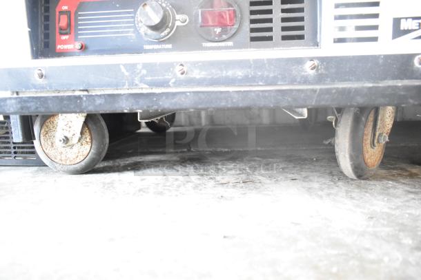 Metro HM2000 Heated Holding Cabinet on casters. Features temperature control, thermometer, signs of wear, uses 115 volts.