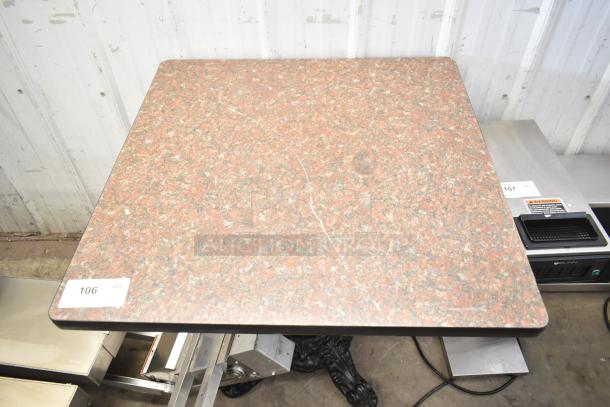 Dining height table with a square, granite-patterned surface. Sturdy base, tag numbered 106. Good condition.