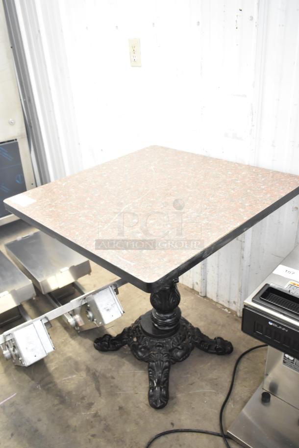 Dining height table with square granite top, ornate black cast iron base. Appears in good condition.