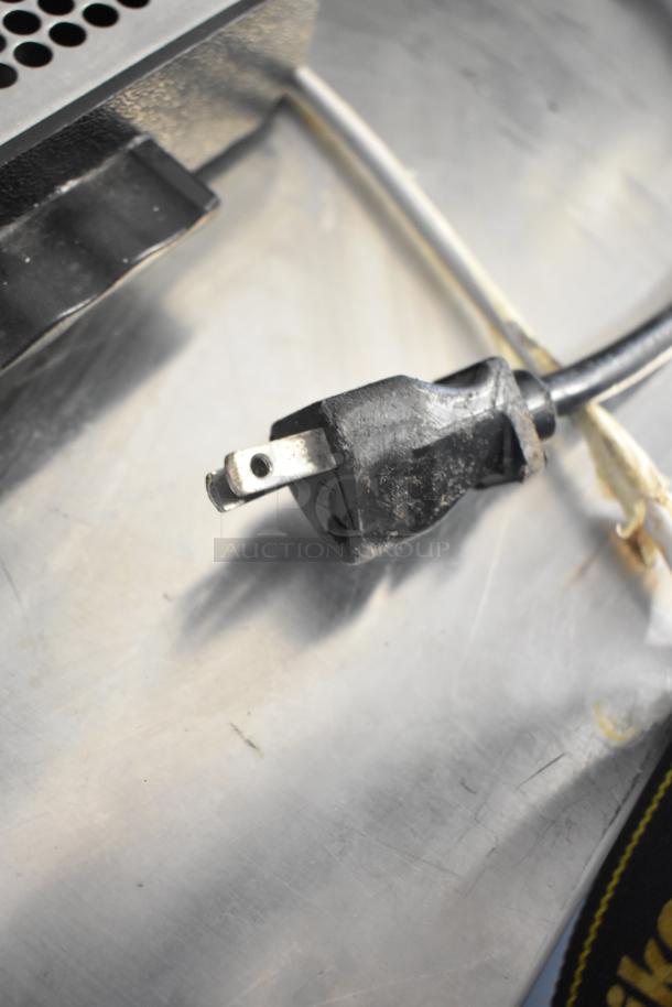 Bunn Commercial Coffee Bean Grinder power plug, indicating 120 volts, 1 phase compatibility, resting on a metal surface.