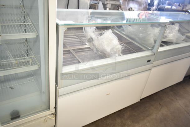 Commercial gelato display case merchandiser, glass front, multiple metal shelves, moderate condition, ideal for shop use.