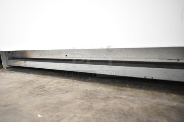 Commercial floor-style gelato display case merchandiser, featuring a metal base and glass front, pristine condition.