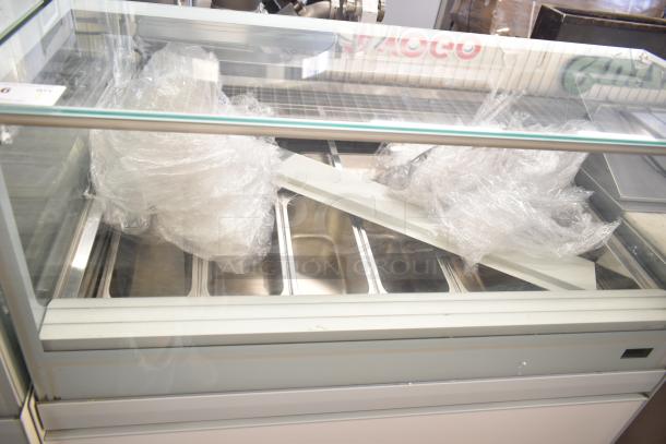Commercial floor-style gelato display case merchandiser with glass front, multiple trays, and protective plastic wrap, excellent condition.