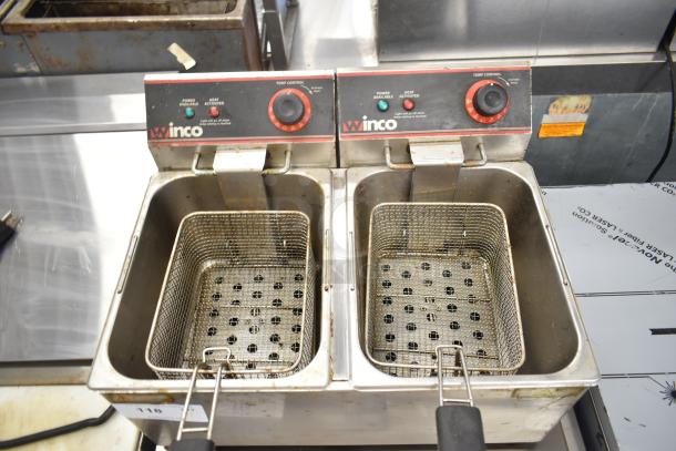 Winco countertop electric fryer with 2 bays, includes 2 metal fry baskets. Control knobs visible, used condition.