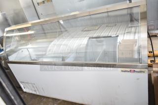 Commercial floor style ice cream dipping cabinet with glass top, visible wear, brand label present, spacious interior.