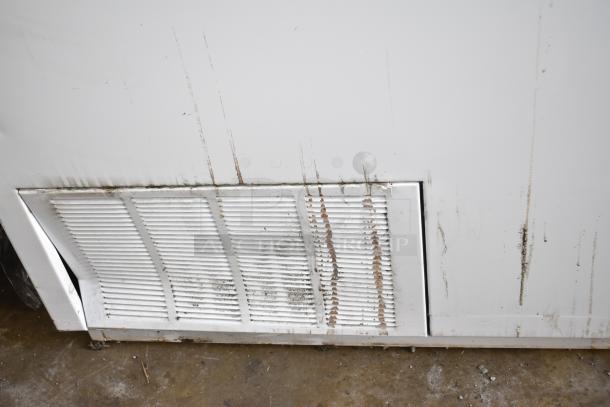 Commercial floor-style ice cream dipping cabinet with visible wear and dirt on the exterior surface and vents.