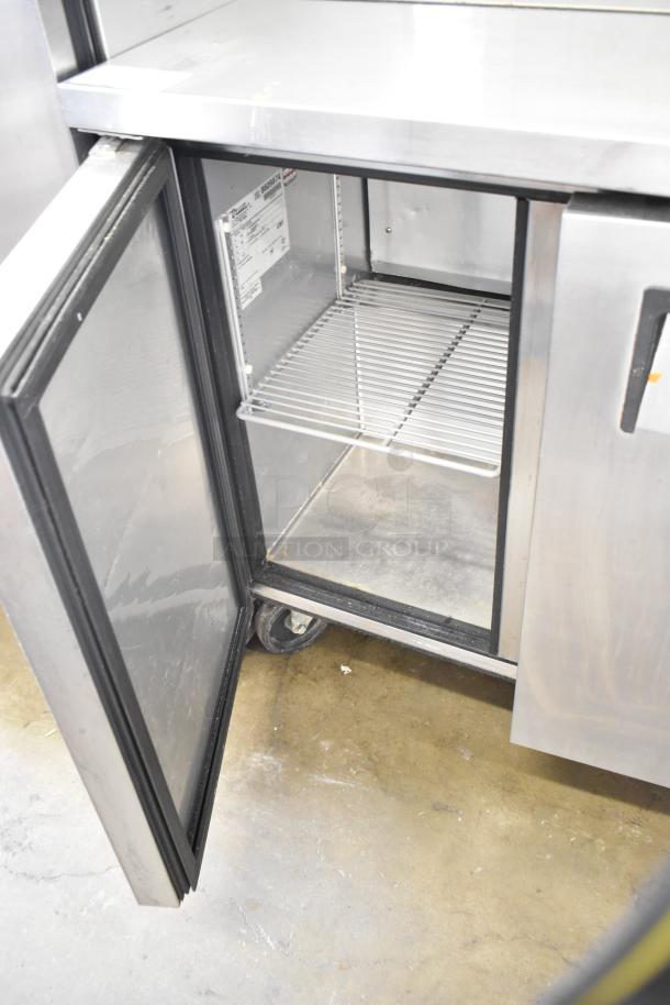 True TSSU-36-08 commercial 2-door undercounter cooler with open door, shelving, and label visible; on casters, 115 volts.
