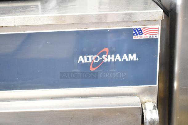 Alto Shaam heated holding cabinet on commercial casters, stainless steel, "Made in U.S.A." label, visible wear.