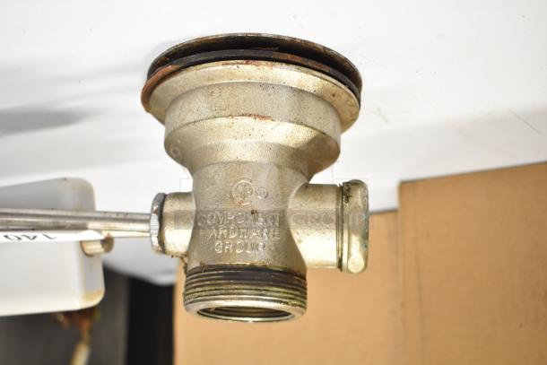 Industrial metal sink drain labeled "Component Hardware Group" showing threading and corrosion, used condition.