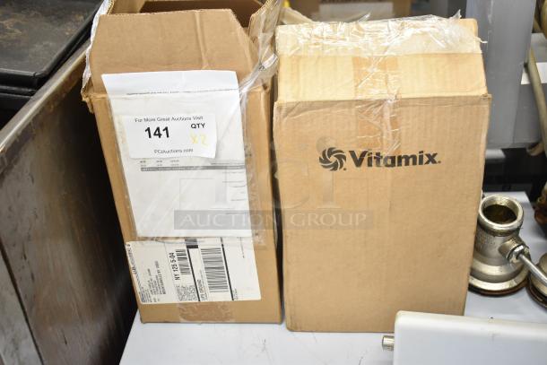Two brand new Vitamix blender pitchers in boxes, marked "scratch and dent," auction tag says "QTY x2."