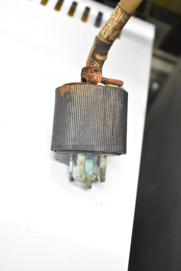 Rusty metal component, possibly used in machinery, with visible corrosion and worn texture.