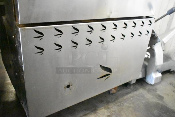 Commercial smoking cabinet with decorative venting cutouts, stainless steel, used condition, minor surface wear.