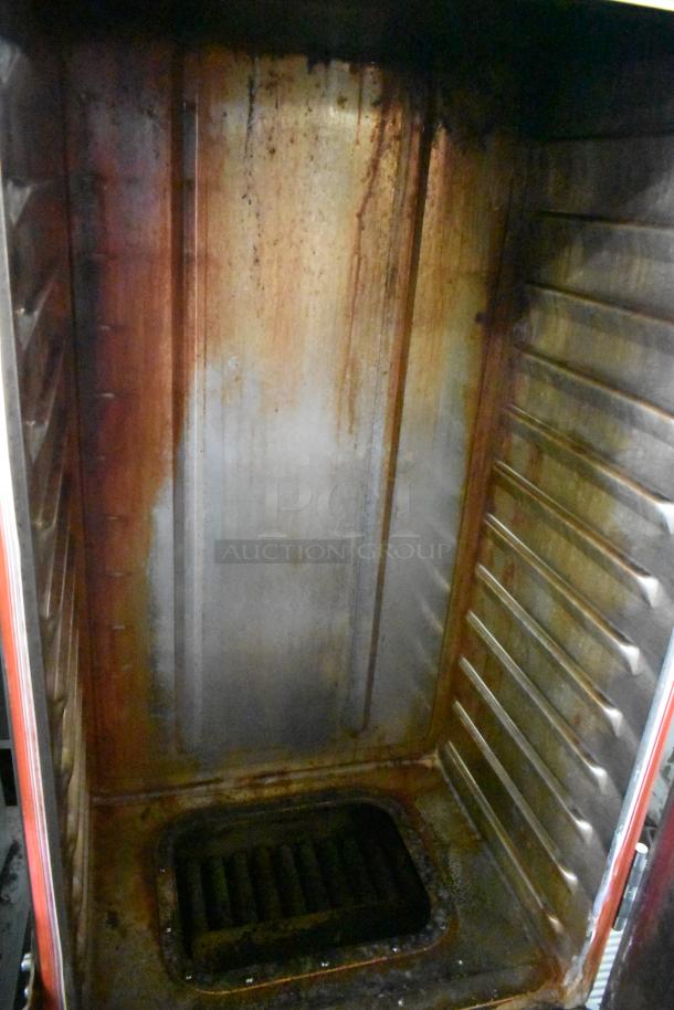 Commercial smoking cabinet interior, showing metal racks and visible signs of use. Sturdy build, ideal for smokers.