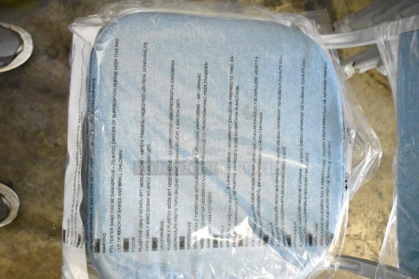 Blue fabric seat of Flash Furniture HERCULES Series banquet chair, partially wrapped in plastic with safety warnings.