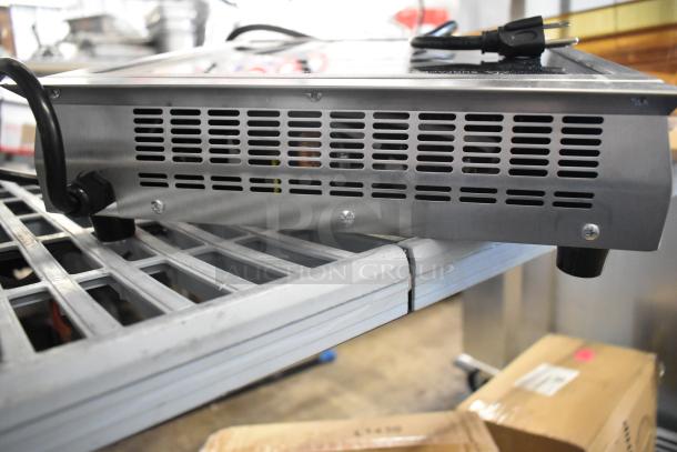 Brand new Avantco 177IC1800 countertop induction cooker, 120V, 1-phase, with minor scratches and dents, on metal rack.