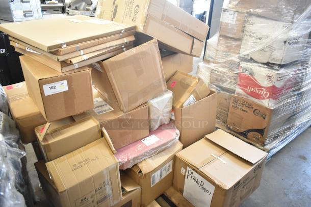Boxes of brand new scratch and dent items, including hot food cups and vacuum packaging pouches, stacked in a warehouse.