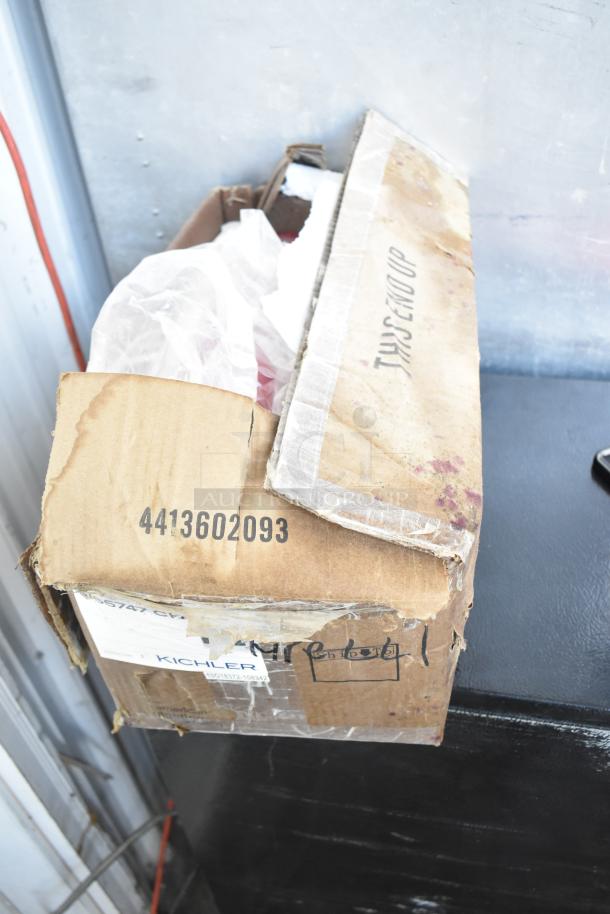 Box containing brand new Kichler S155747 CH amidst scratch and dent items. Labels and marks visible.