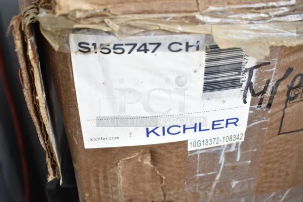 Cardboard box labeled "Kichler S155747 CH," showing slight wear. Contains scratch and dent items.