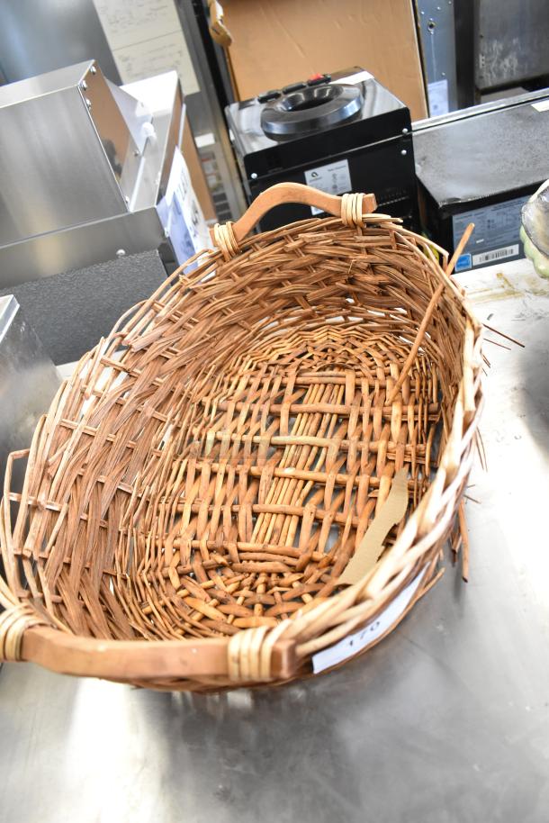 Woven basket with sturdy handle, part of 11-item auction lot including dish, wire basket, and slicer. Good condition.