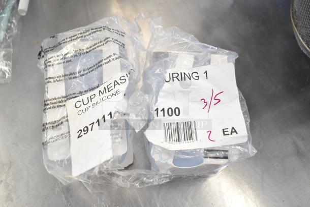 6 various kitchen items including OXO 11161100 Good Grips silicone measuring cup. Items in plastic packaging.