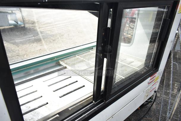 2016 Torrey TEM150+ deli display case, commercial casters, glass front, 120V, 1 Phase, minor wear, interior shelves visible.