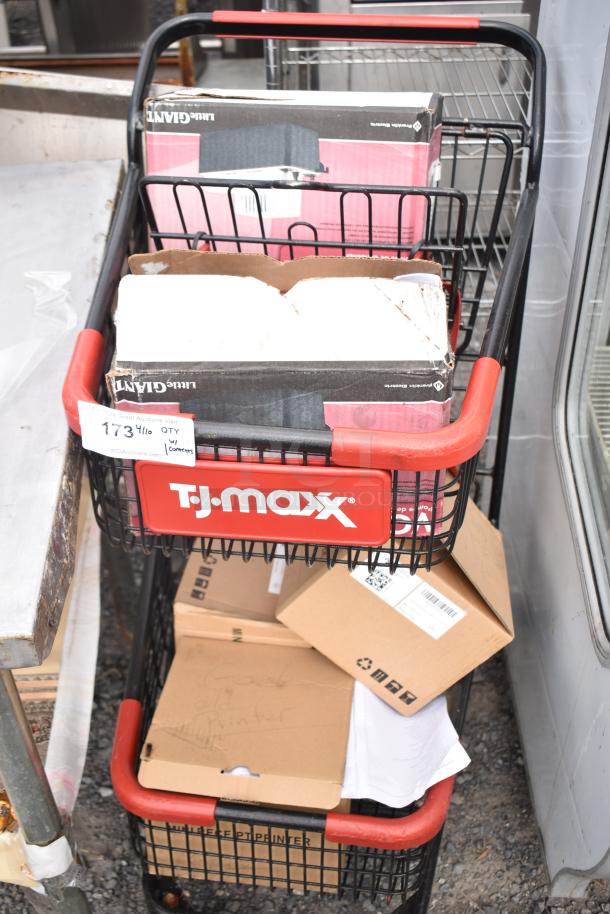 Two-tier TJ Maxx shopping cart filled with various boxes and contents. Cart marked with auction tag "173 4/6 QTY w/ Contents."