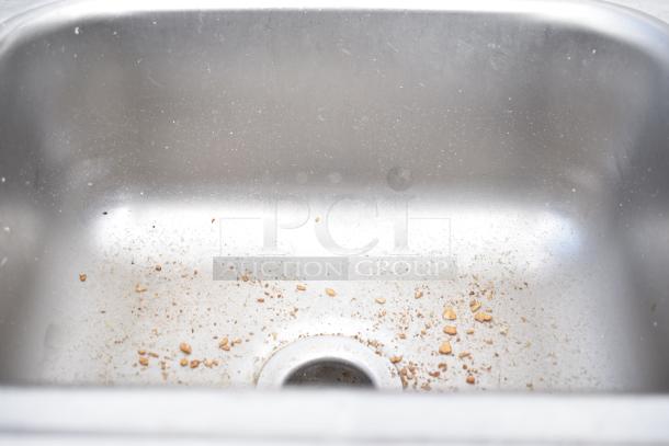 Stainless steel single bay drop-in sink with visible surface wear and debris, auction for 2 units.