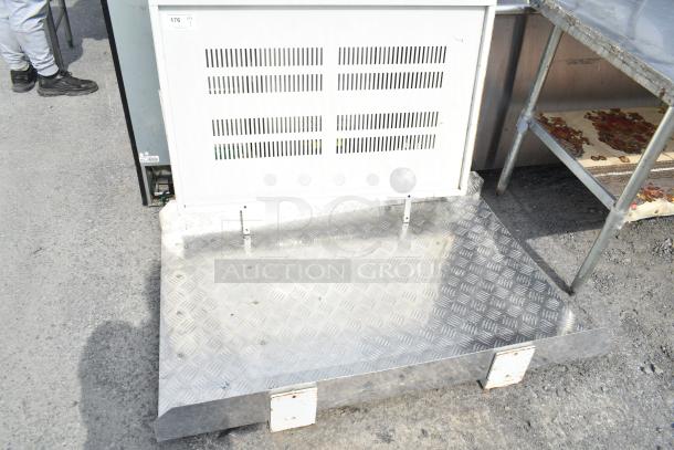 Metal panel with vent slits, checkered plating, and metal brackets. Tag reads "176 QTY 1". Used, outdoor condition.