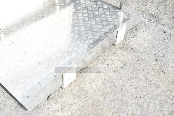 Aluminum tread panel, featuring a diamond pattern, mounted on a metal frame. Shows minor wear, suitable for industrial use.