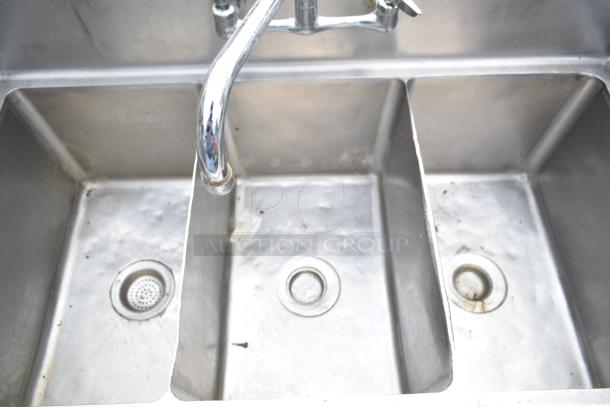 Commercial 3 bay sink with silver finish, visible wear, three compartments, and a central faucet. Ideal for industrial use.