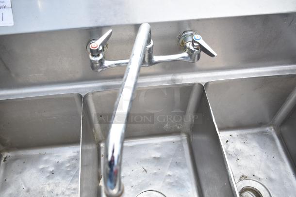 Commercial 3 bay sink, stainless steel, dual faucets, moderate wear, some visible stains, ideal for kitchen use.