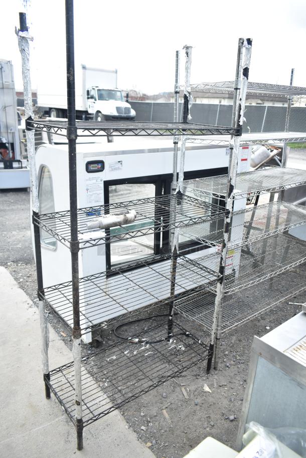 Black finish 4-tier wire shelving unit, used condition, requires dismantling, freight charges apply.