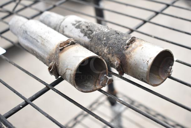 Black 4-tier wire shelving unit with wear, requiring dismantling by buyer. Consider freight charges for shipping.