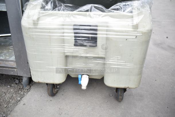 Cambro tan poly portable ice bin on commercial casters, wrapped in plastic. Features a drainage spout and sturdy design.