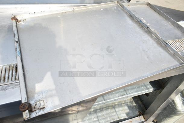 Commercial soda station with under shelves and doors, metal surface, visible wear, designed for beverage service.