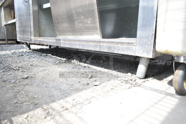 Commercial soda station with under shelves and doors, stainless steel, used condition, sturdy wheels, and storage space.