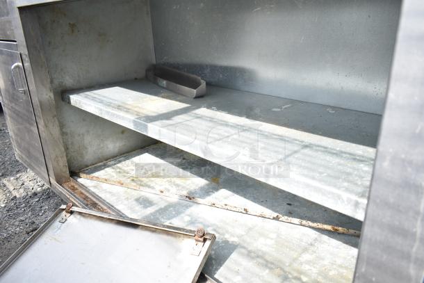 Commercial soda station with under shelves and doors, showing signs of wear, with open metal shelving and durable construction.