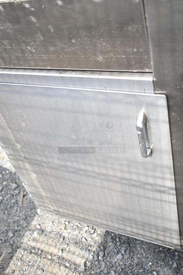 Commercial soda station with under shelves and doors, stainless steel, visible wear, ideal for restaurant use.