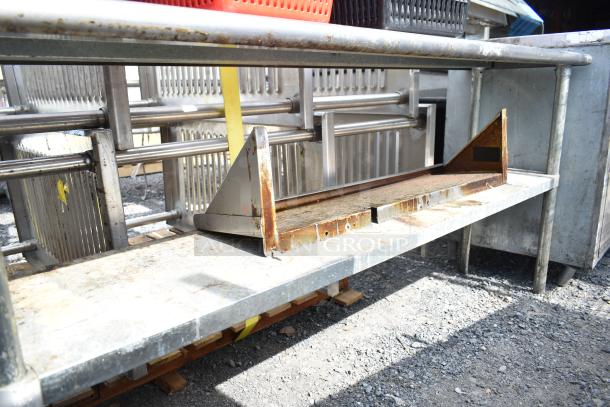 Commercial 2 tier metal over shelf with visible rust and wear, includes various baskets on lower shelf.
