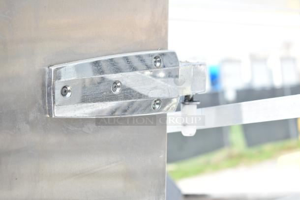 Stainless steel walk-in door hinge with visible screws, in good condition.
