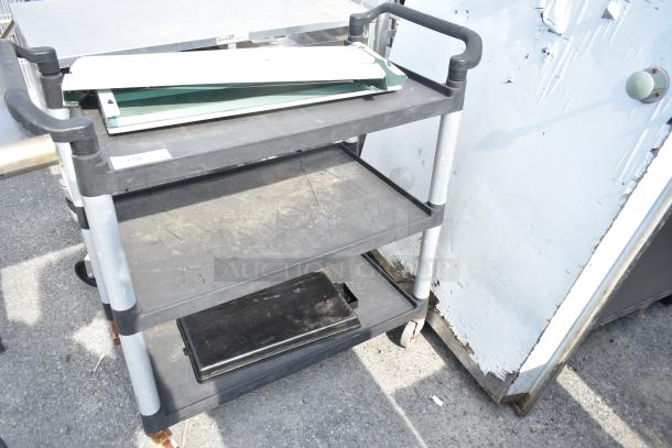 Black Poly 3 Tier Cart on commercial casters, featuring sturdy construction, visible wear, three shelves, and metal handles.