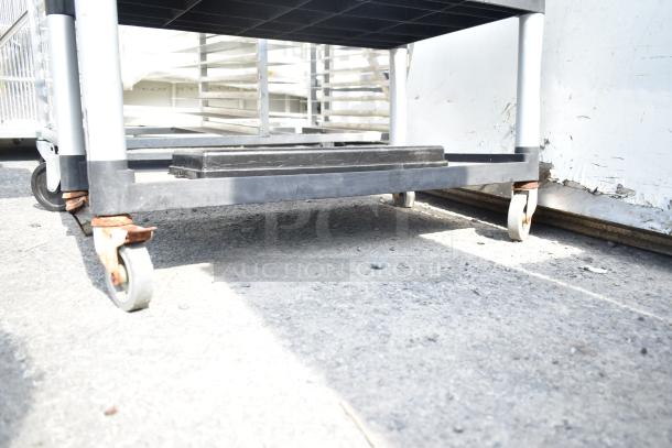 Black Poly 3-tier cart with commercial casters, showing wear and rust on wheels, ideal for heavy-duty use.