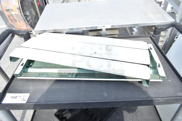 Black poly 3 tier cart on commercial casters, good condition, features durable shelves and ergonomic handles for easy mobility.