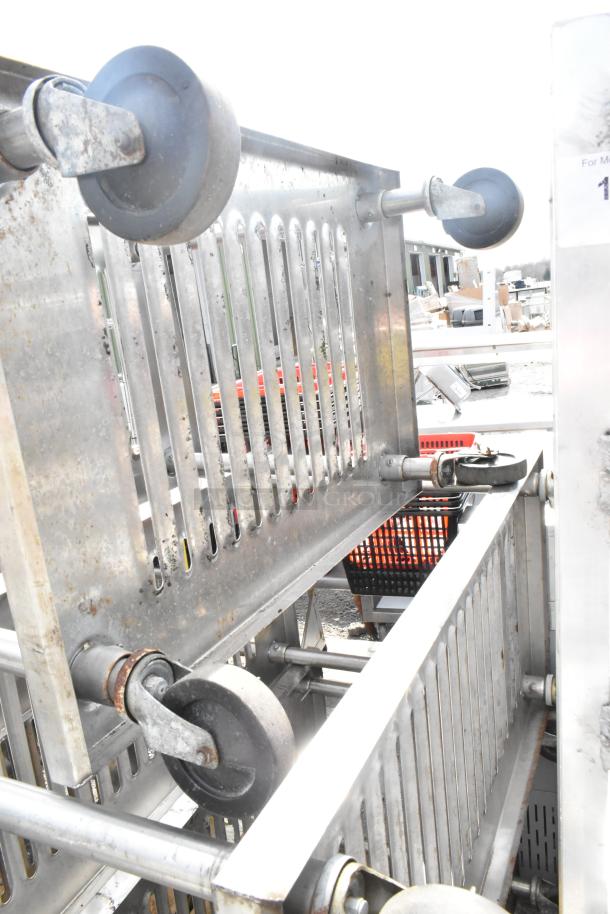 Three metal 4-tier shelving units on commercial casters, used condition, buyer must dismantle, freight charges apply.