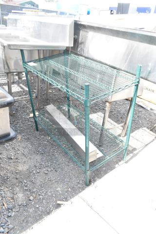 Green finish 2-tier wire shelving unit, sturdy metal construction, outdoor setting. Buyer must dismantle; consider freight costs.