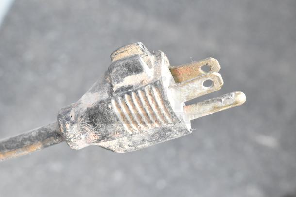 A dusty power plug of a Shop Air 3613D-12BH-SWH Floor Fan, 115 volts, 1 phase, showing signs of wear.